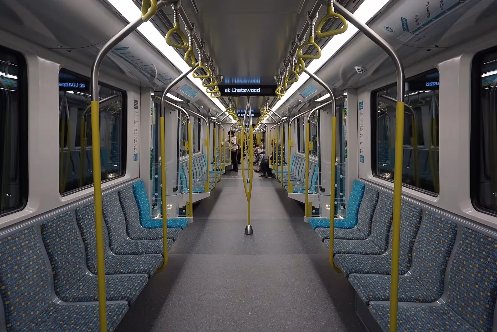 Interior of a modern metro train in New South Wales with spacious seating and handrails.