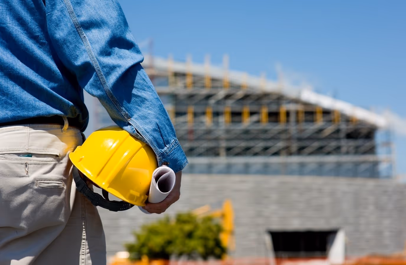 Construction worker holding a hard hat and plans, possibly on an RDO in Australia.