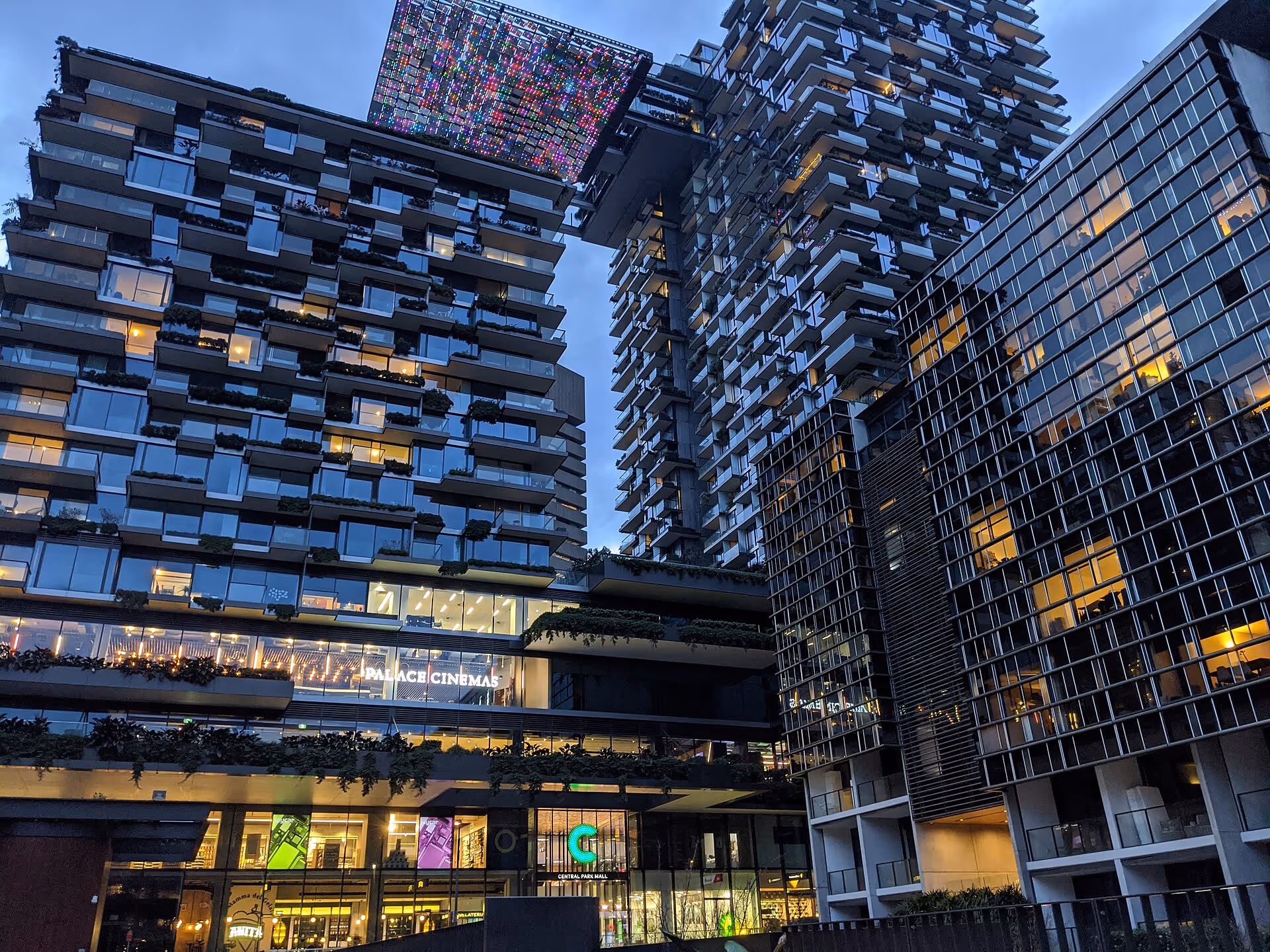 Mixed-use Central Park building in Sydney with residential towers, retail spaces, and a cantilevered panel of colored lights.