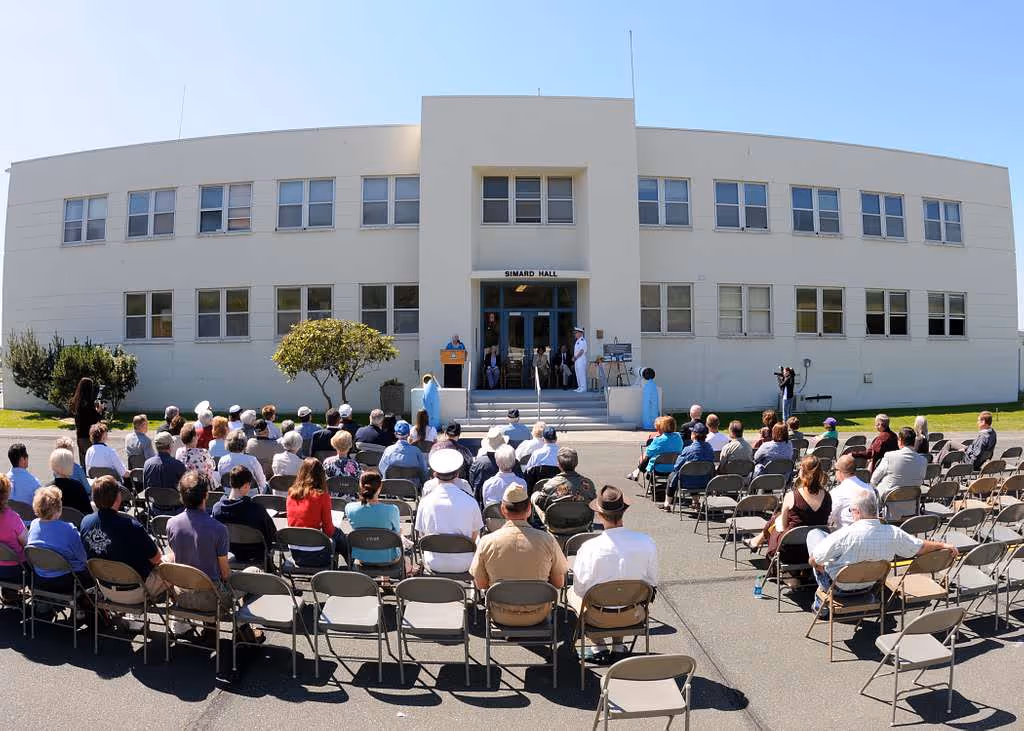 Audience seated outside during a building dedication ceremony.
