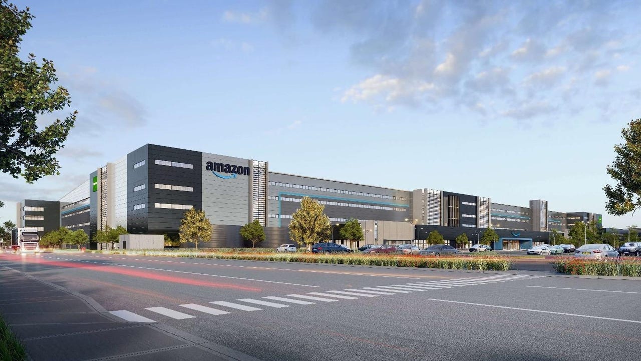 Exterior view of Amazon Fulfillment Center in Kemps Creek, showing a large multi-level warehouse with parking and delivery truck access.