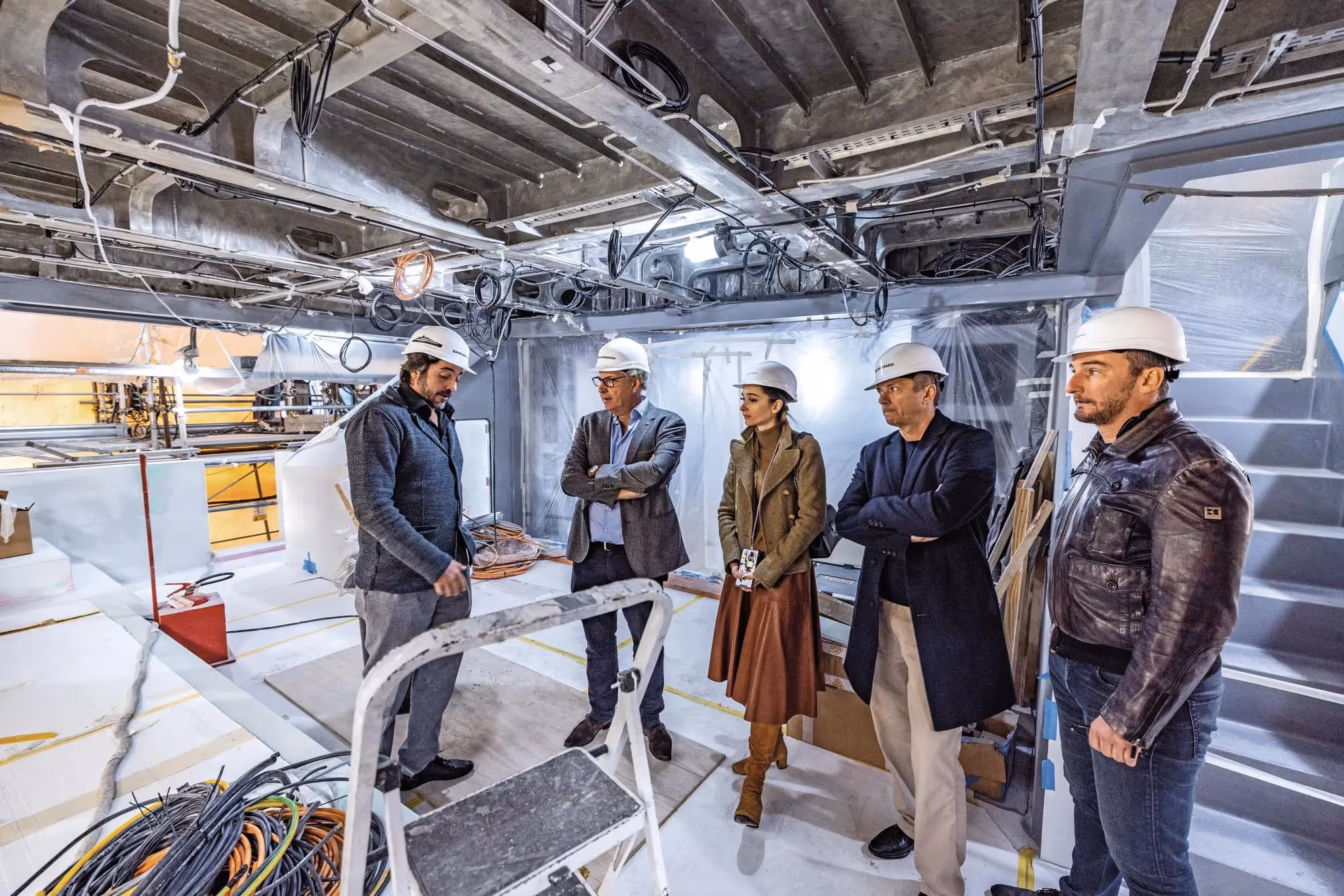 Yacht construction team inspecting fit-out progress inside vessel interior