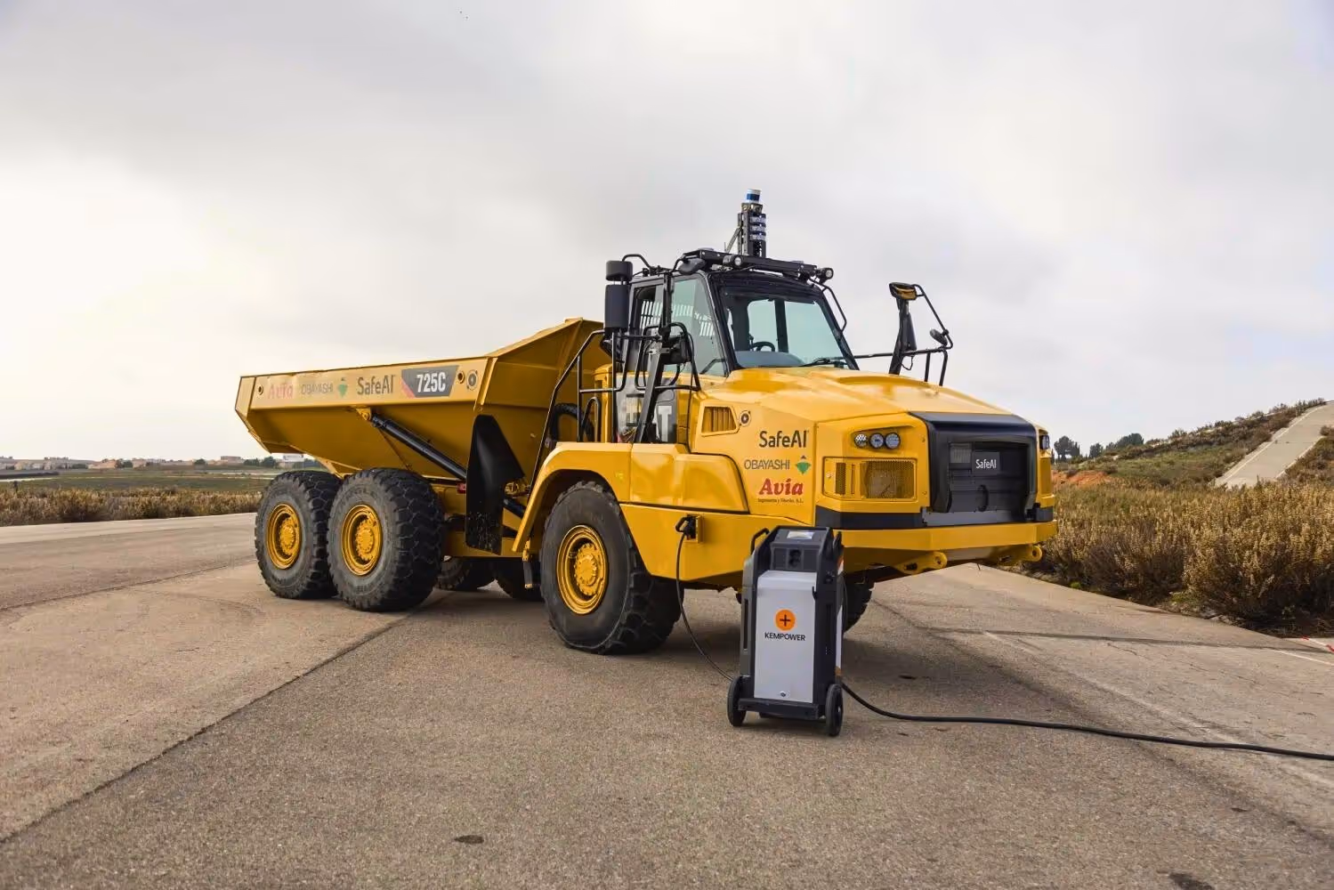Electric autonomous Caterpillar 725C dump truck by Obayashi and SafeAI connected to Kempower charger.