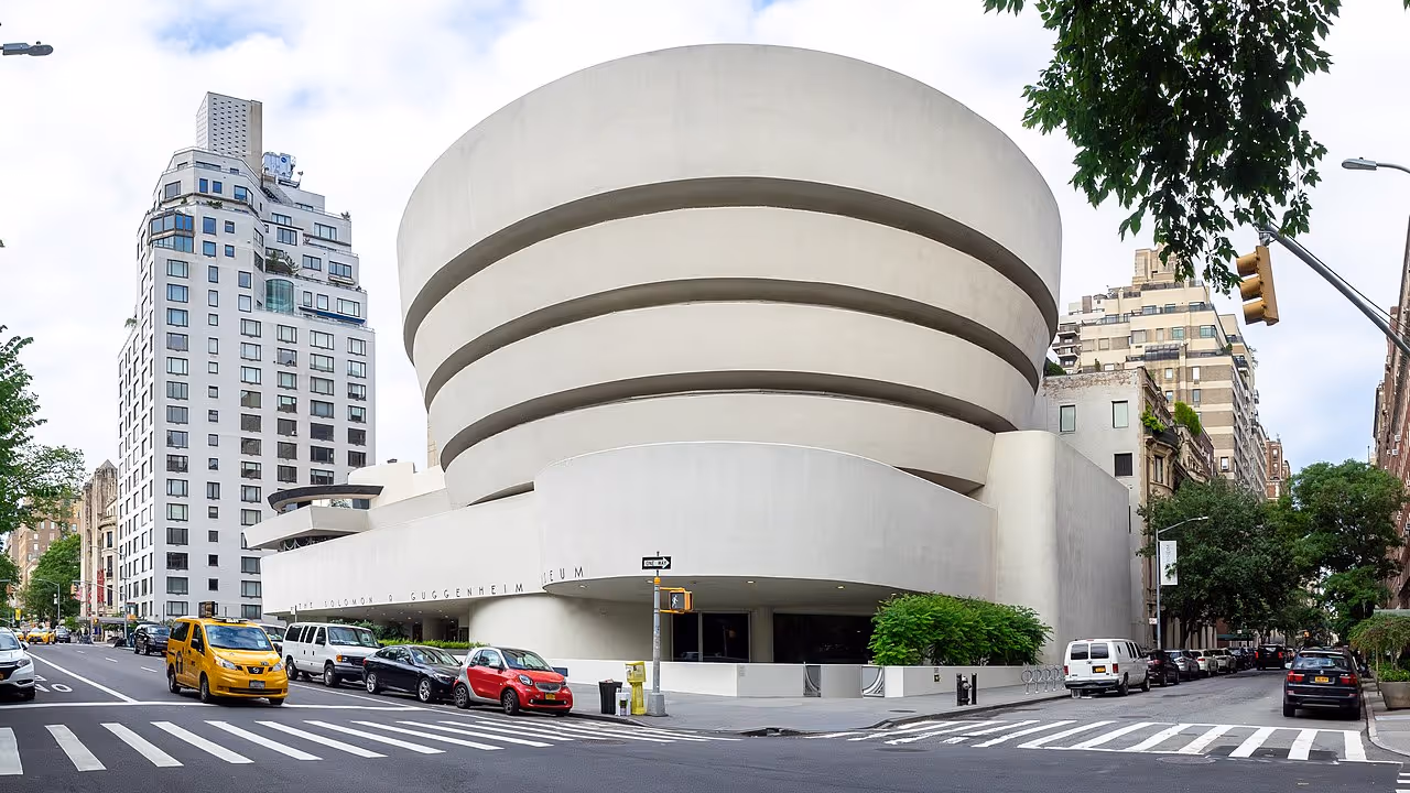 A white cylindrical building with smooth, continuous curves, standing out among Manhattan’s grid.