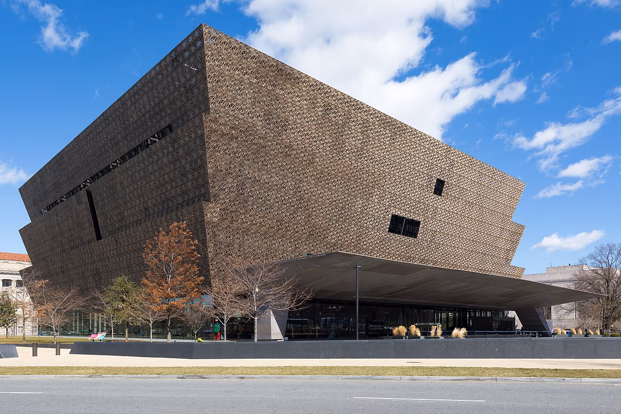 A tiered bronze-colored building with a lattice-pattern façade, inspired by African art, located on the National Mall.