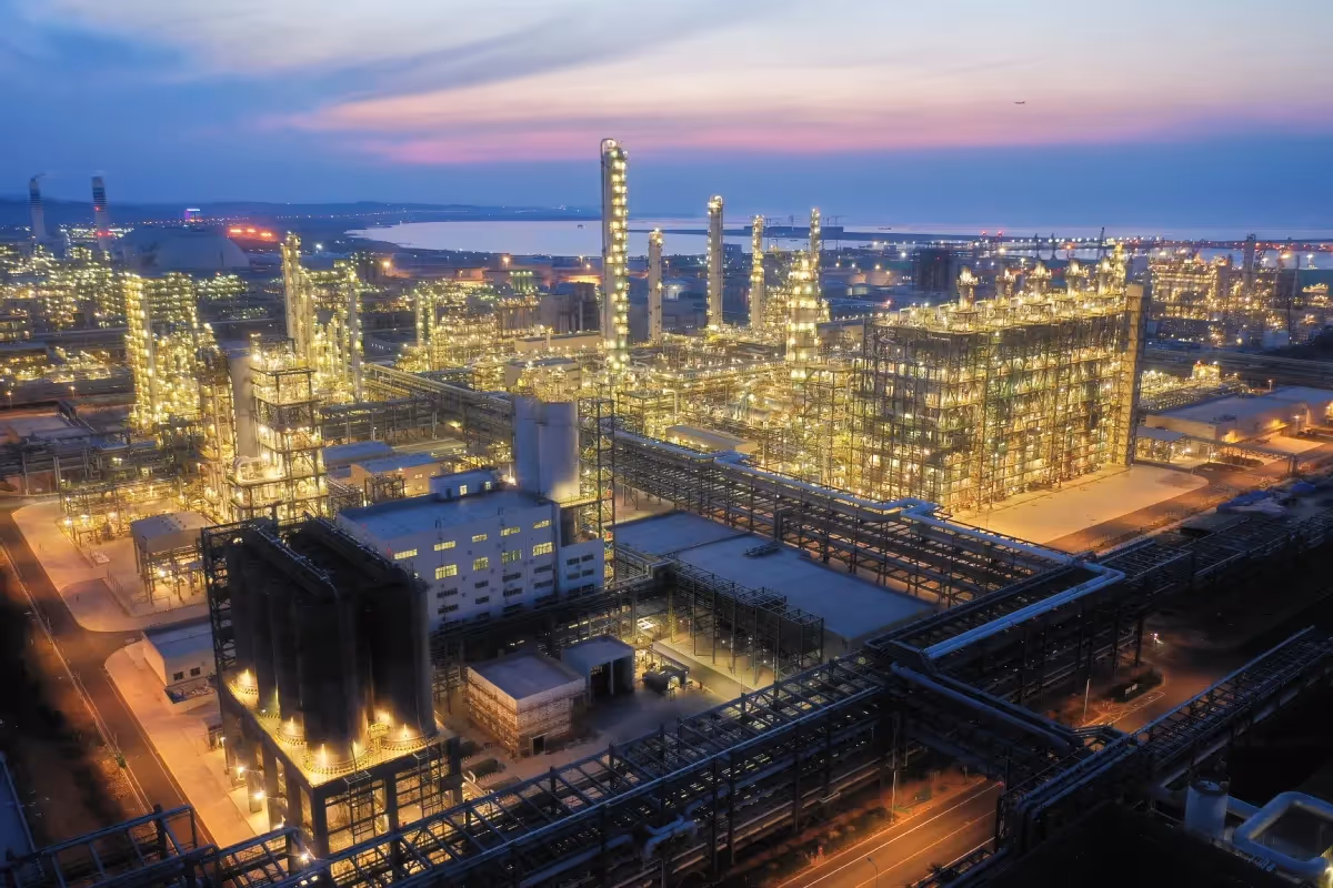 Petrochemical plant illuminated at night with dense pipework