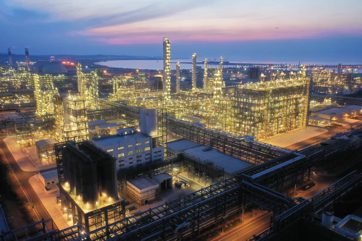 Petrochemical plant illuminated at night with dense pipework