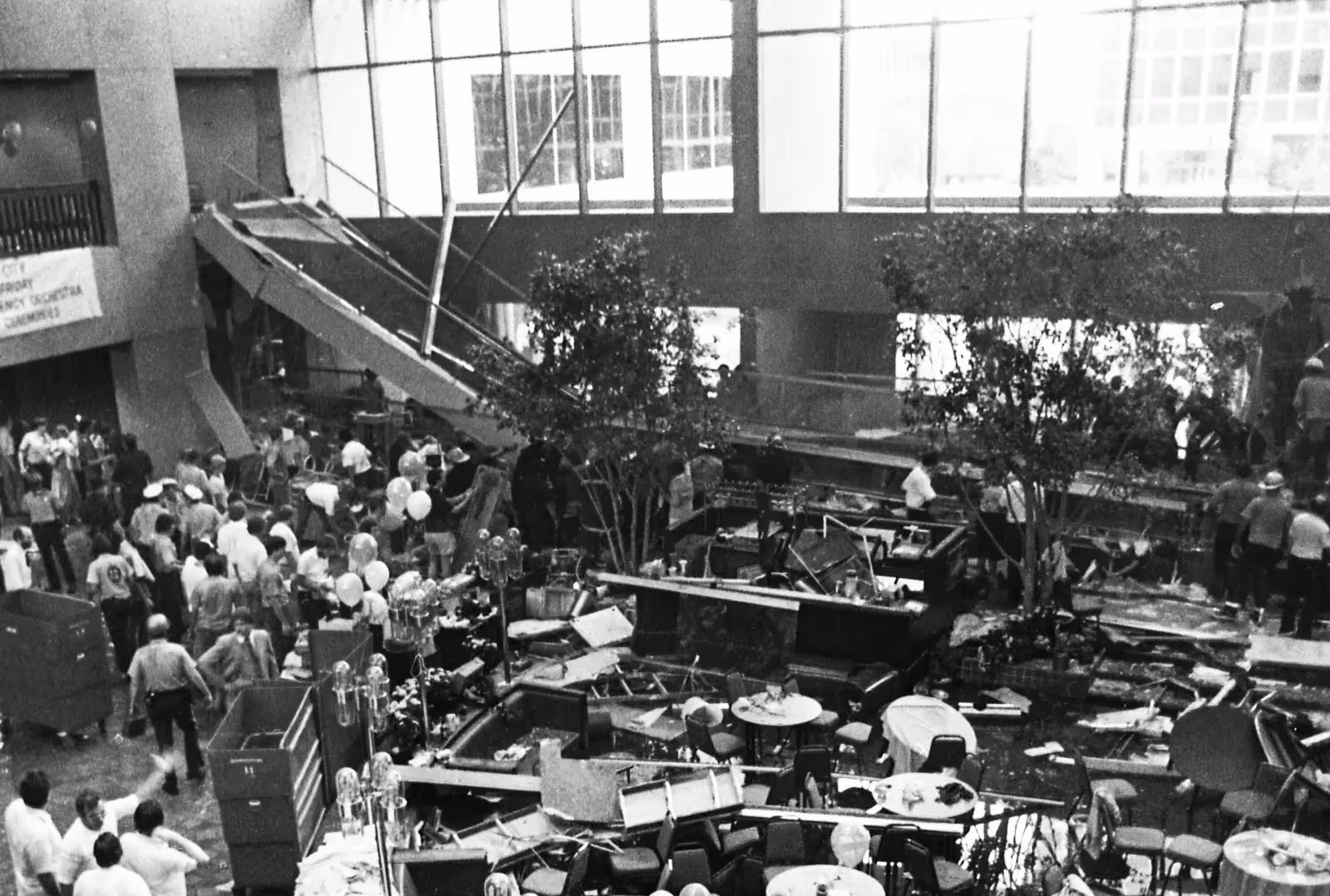 Interior scene of Hyatt Regency hotel showing damage and people gathering after the walkway failure.