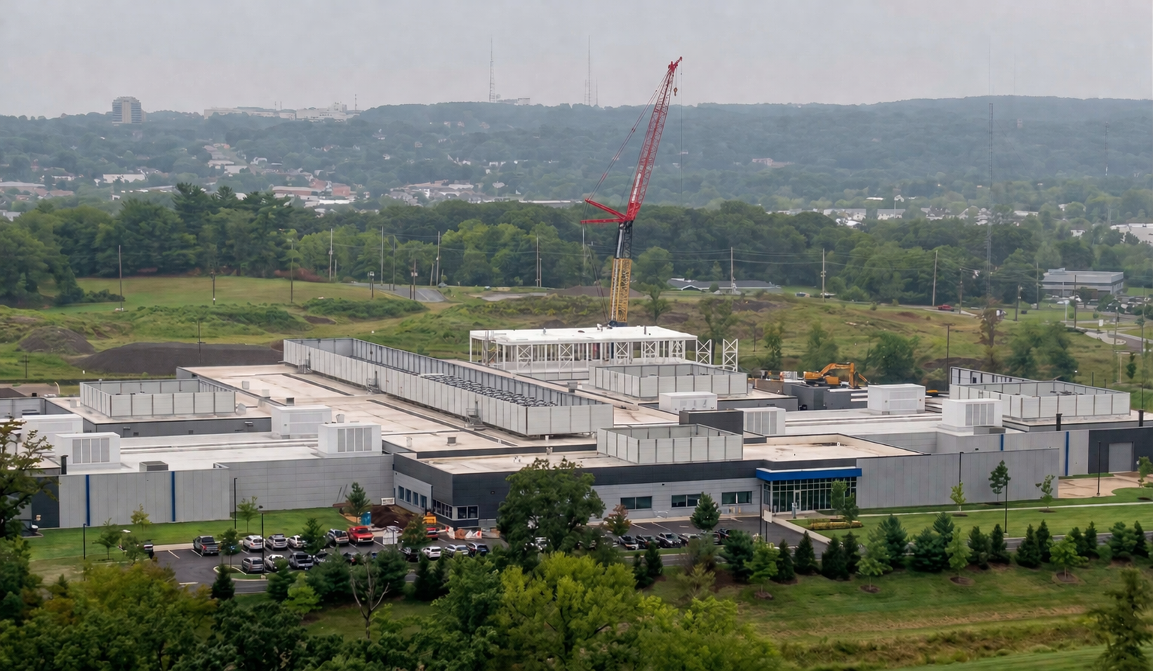 Enterprise data center facility with flat roofs, parking lot, and rear crane