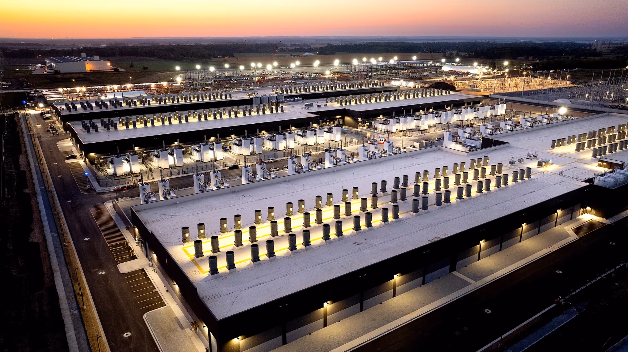 Amazon cloud data center complex with lit equipment yards and long flat-roof buildings