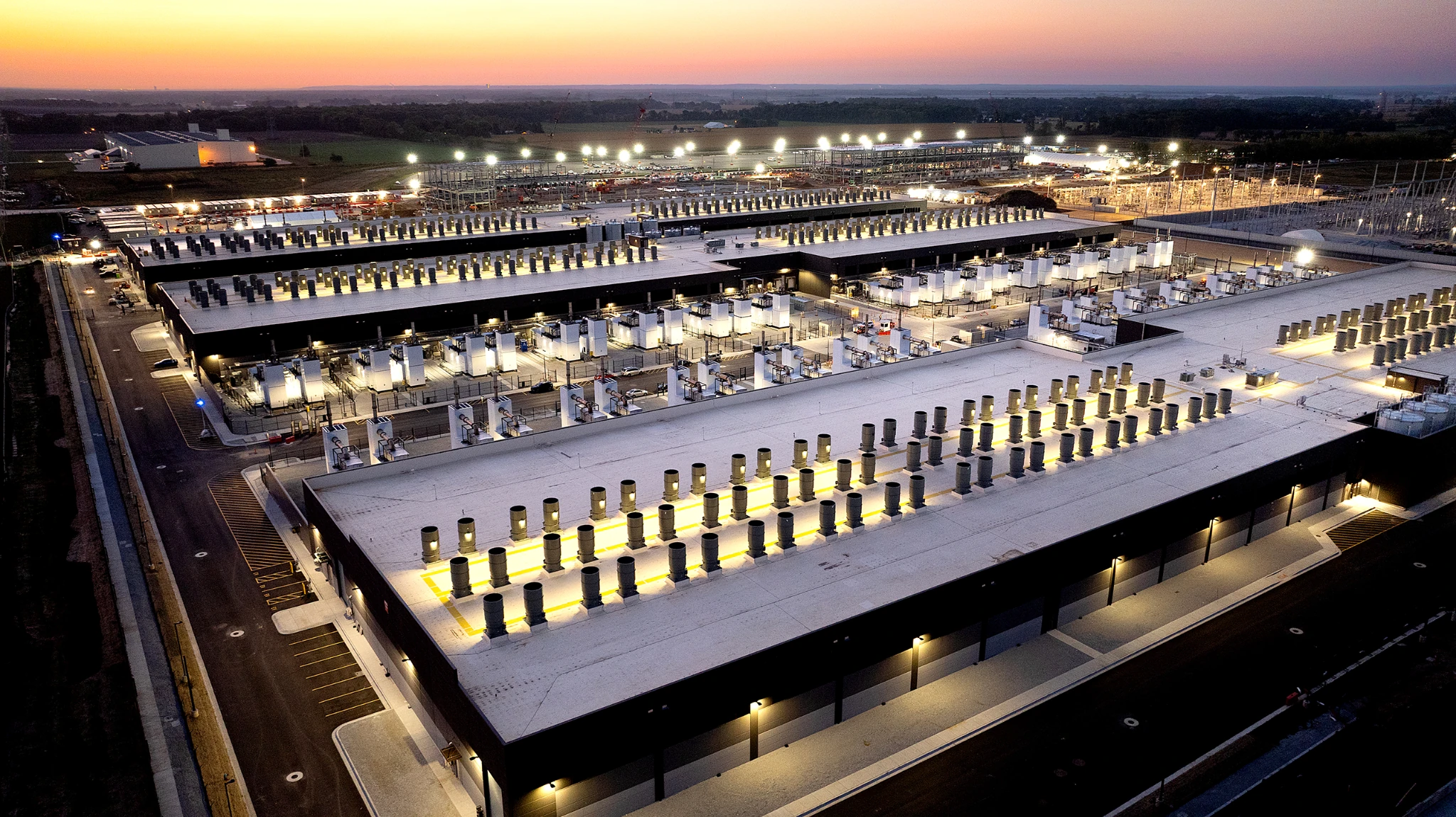 Amazon cloud data center complex with lit equipment yards and long flat-roof buildings