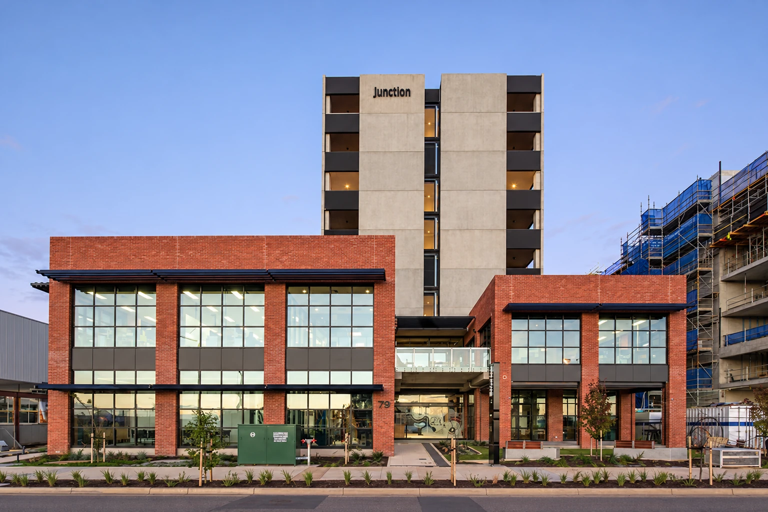 Exterior of Junction Thrive Stage 1, featuring a multi-storey building with red brick façades and large glass windows in Tonsley, Australia.