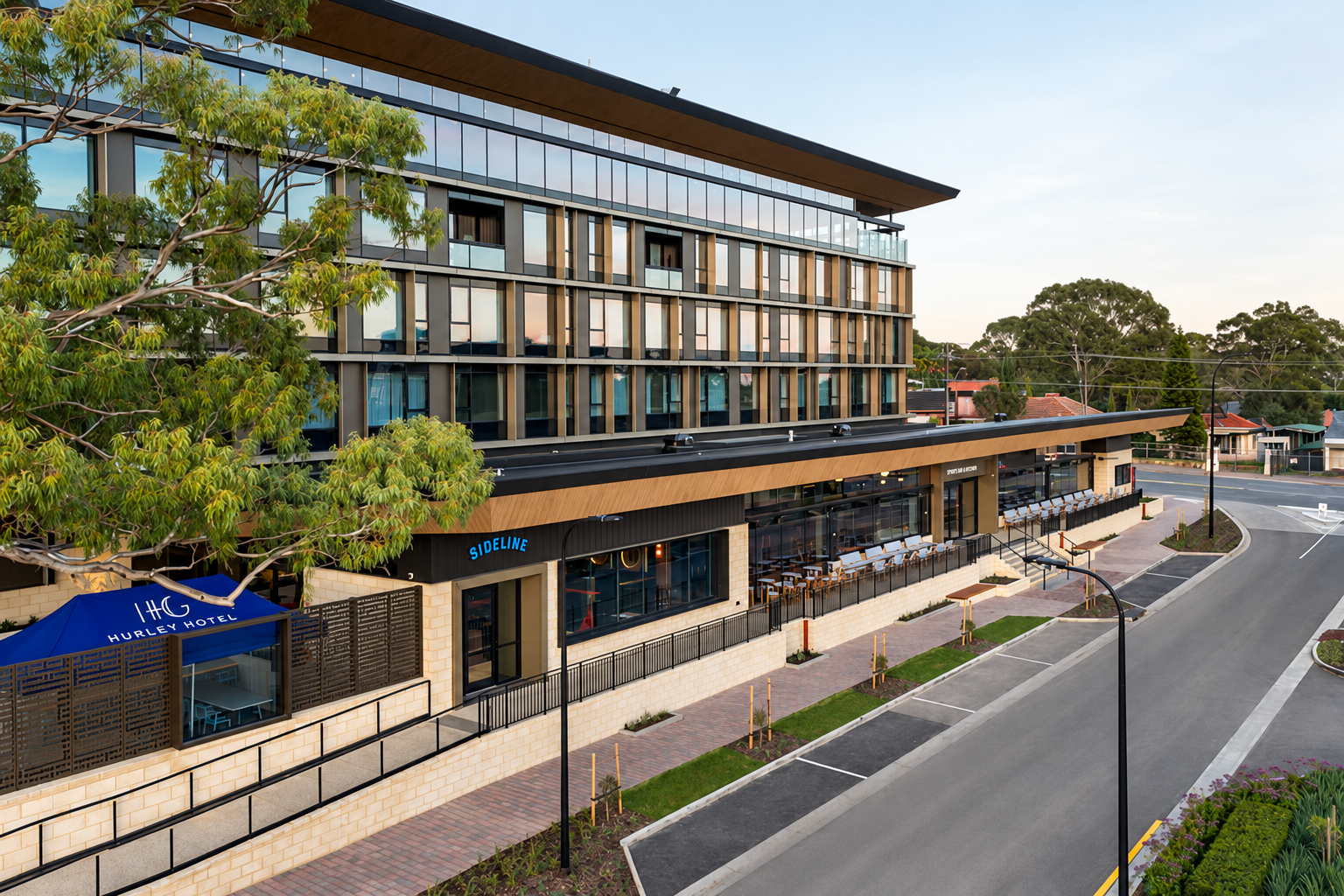 Hotel Panorama exterior with glazed upper floors and street-level outdoor dining.