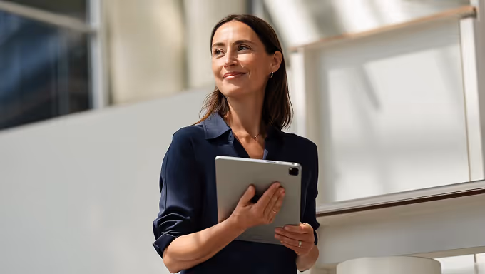 Testimonial from a small business performing construction project management in house, describing 911 as cost-effective, easy to use, and quick to set up. Includes a dashboard with budget and health indicators, and a photo of two professionals reviewing blueprints on-site in a modern construction environment.