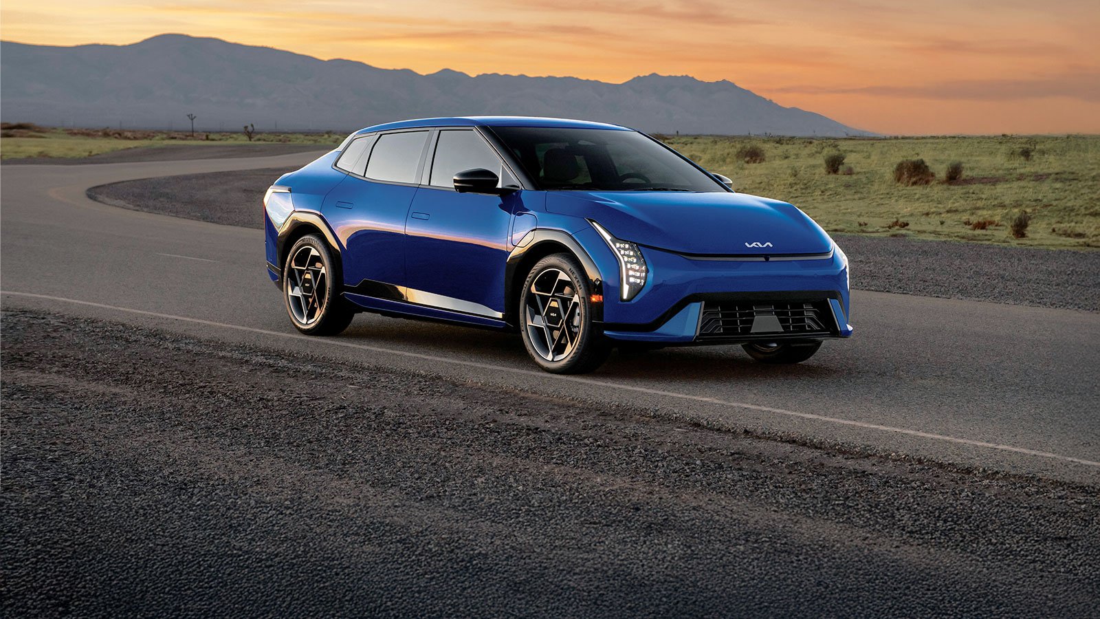 The 2026 Kia EV4 in blue, three-quarter front view at sunset.