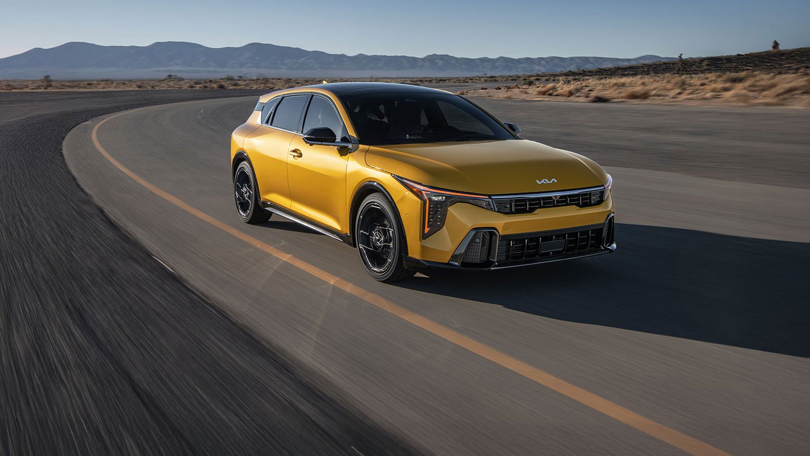 A 2026 Kia K4 Hatchback in yellow, three-quarter front view in motion.