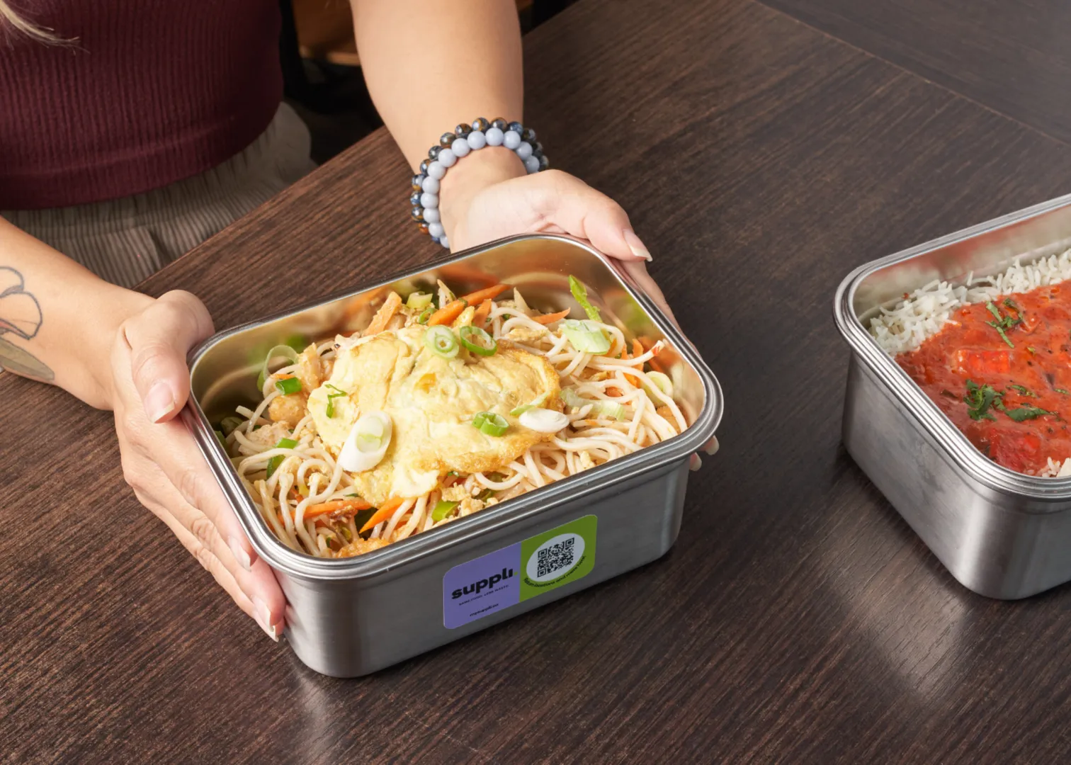 A person holding a small food container
