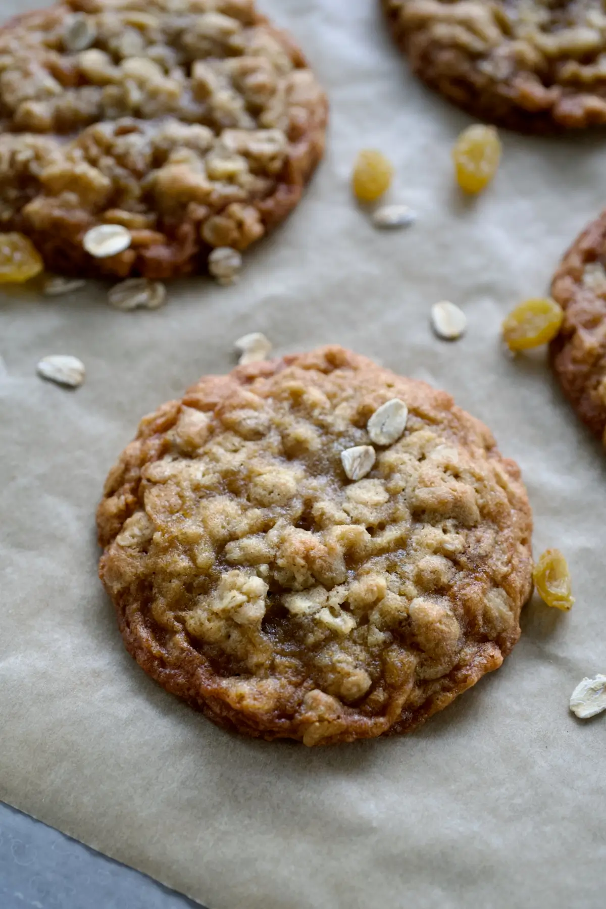 A fresh oatmeal raisin cookie on a baking sheet.