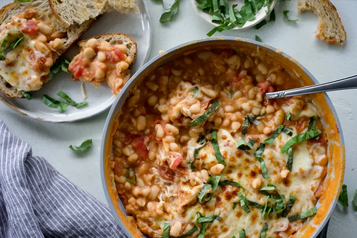 A skillet with cheesy pizza beans.