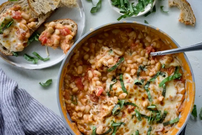 A skillet with cheesy pizza beans.
