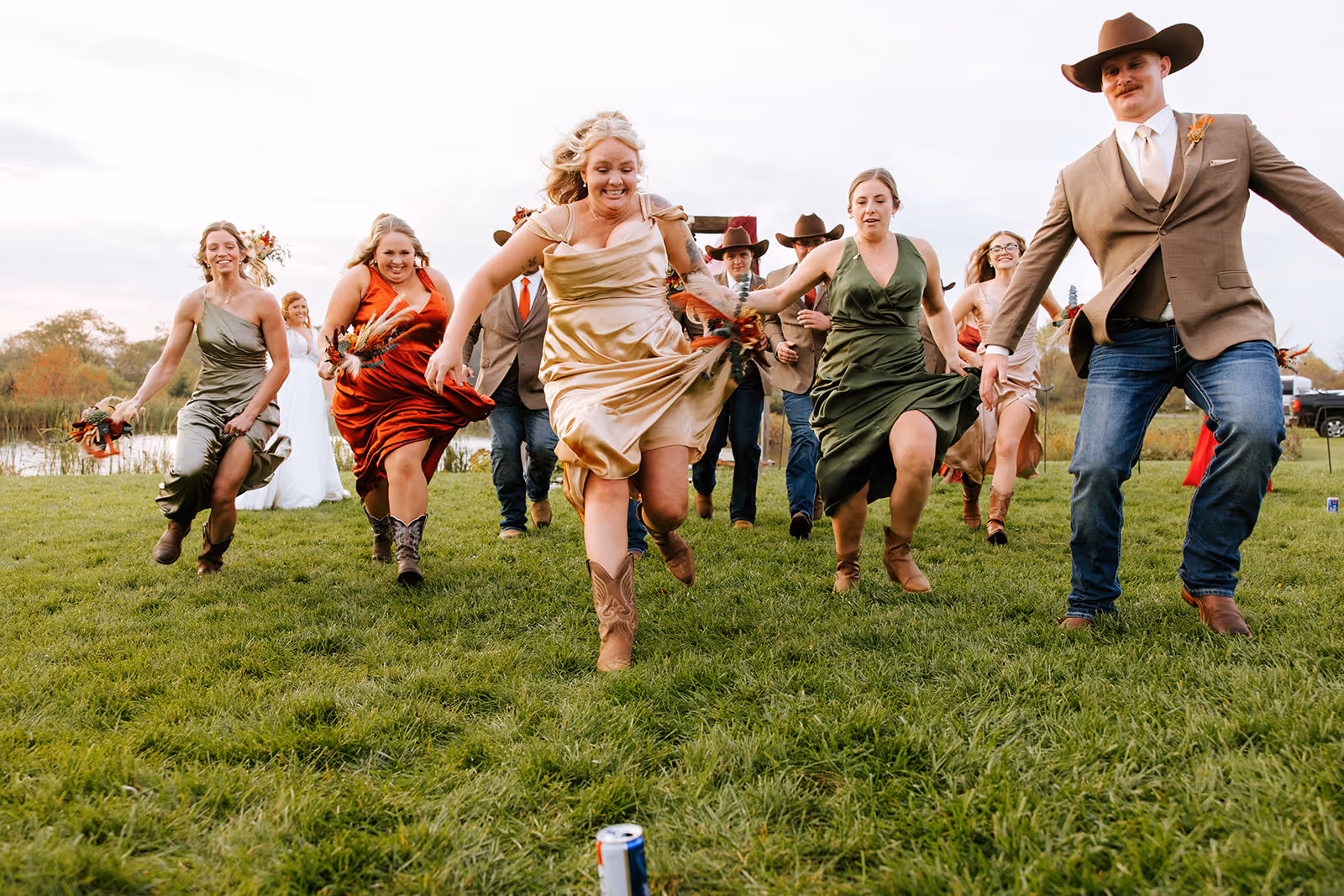 Wedding party running through a field at a Pittsburgh wedding
