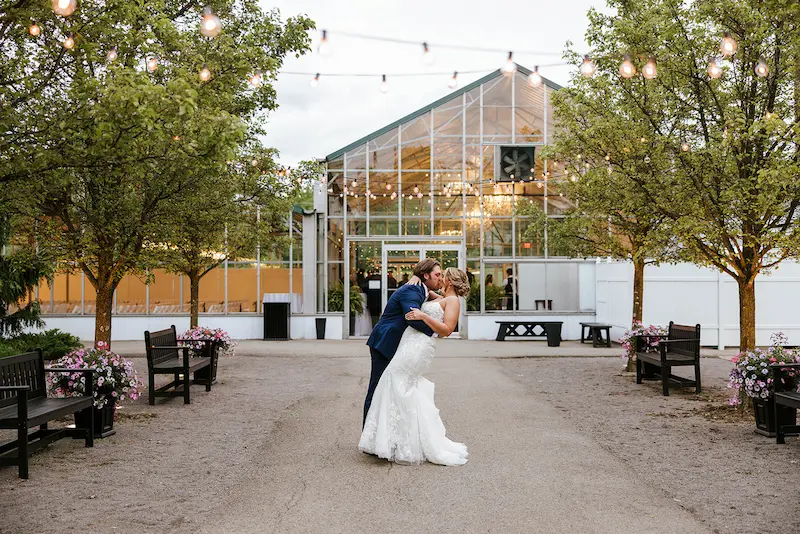Dip kiss outside the glass greenhouse venue