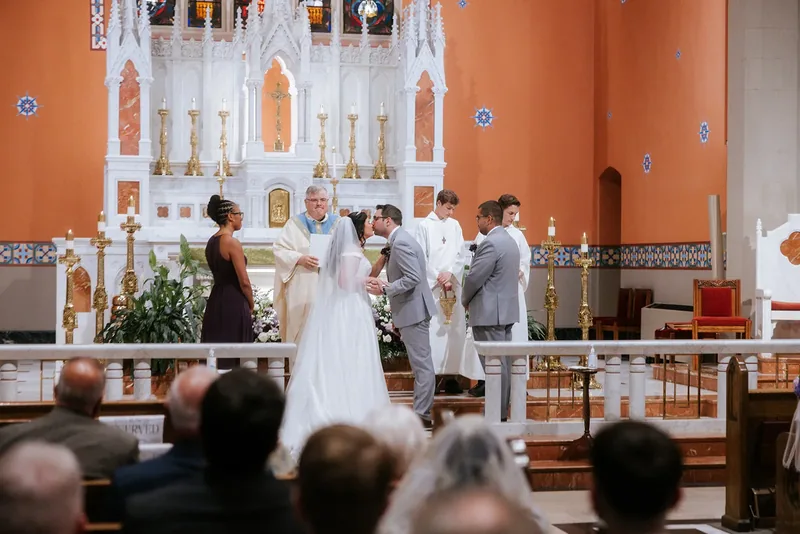 Bride and groom sharing their first kiss during the wedding ceremony