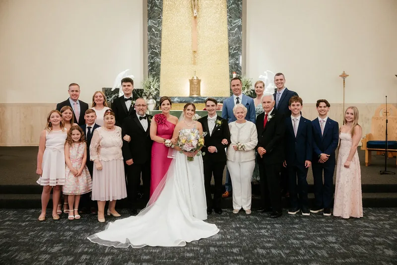 Bride and groom with their extended family at the church altar