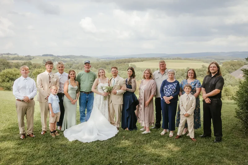 Bride and groom with their extended family on the lawn.