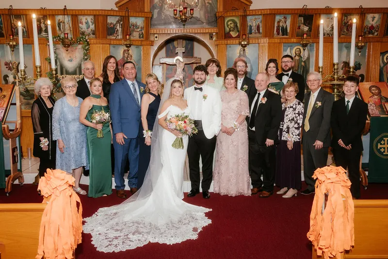 Bride and groom with their extended family at the church altar