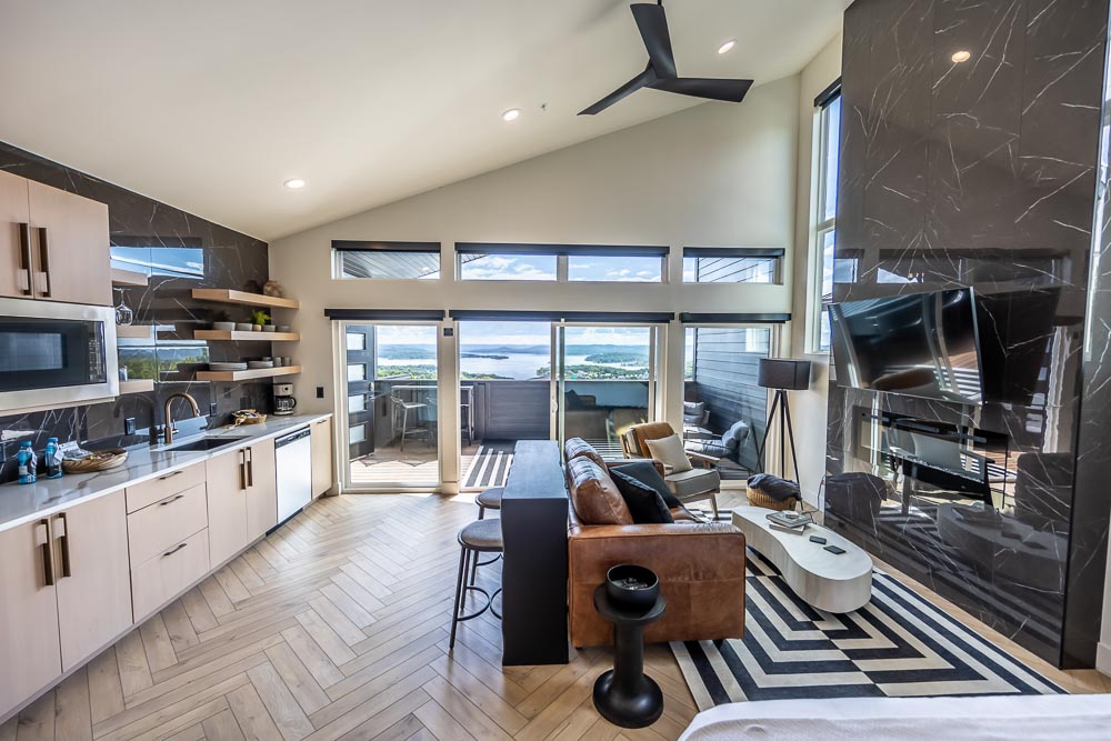 Bright suite interior with vaulted ceiling, kitchenette, gas fireplace and lake-view windows