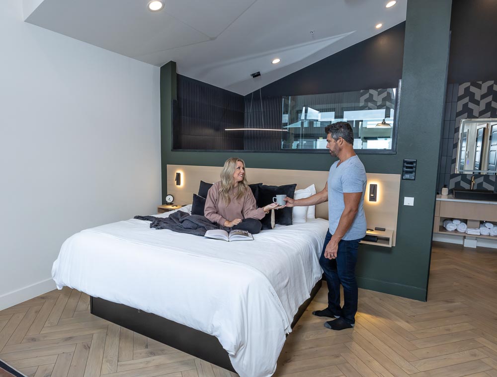 Couple sharing coffee in bed in a Grotto suite