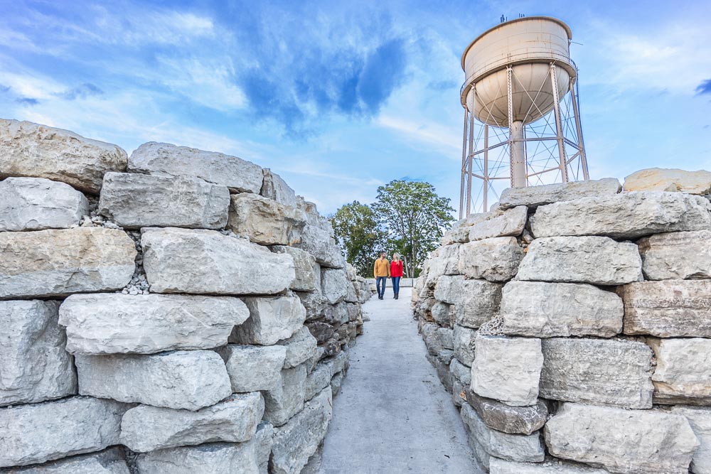 Couple walking between natural stone walls at the entrance to the Cavern Suites