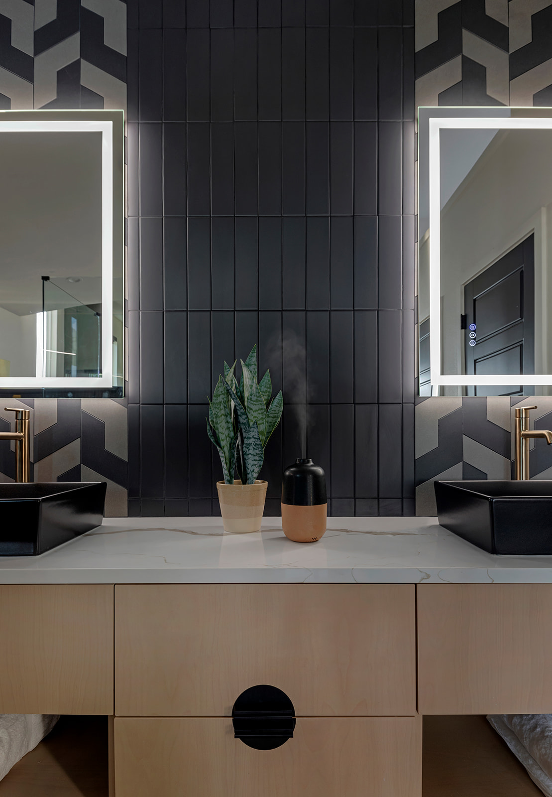 Deckhouse Suite entry with black paneled wall, plant and diffuser
