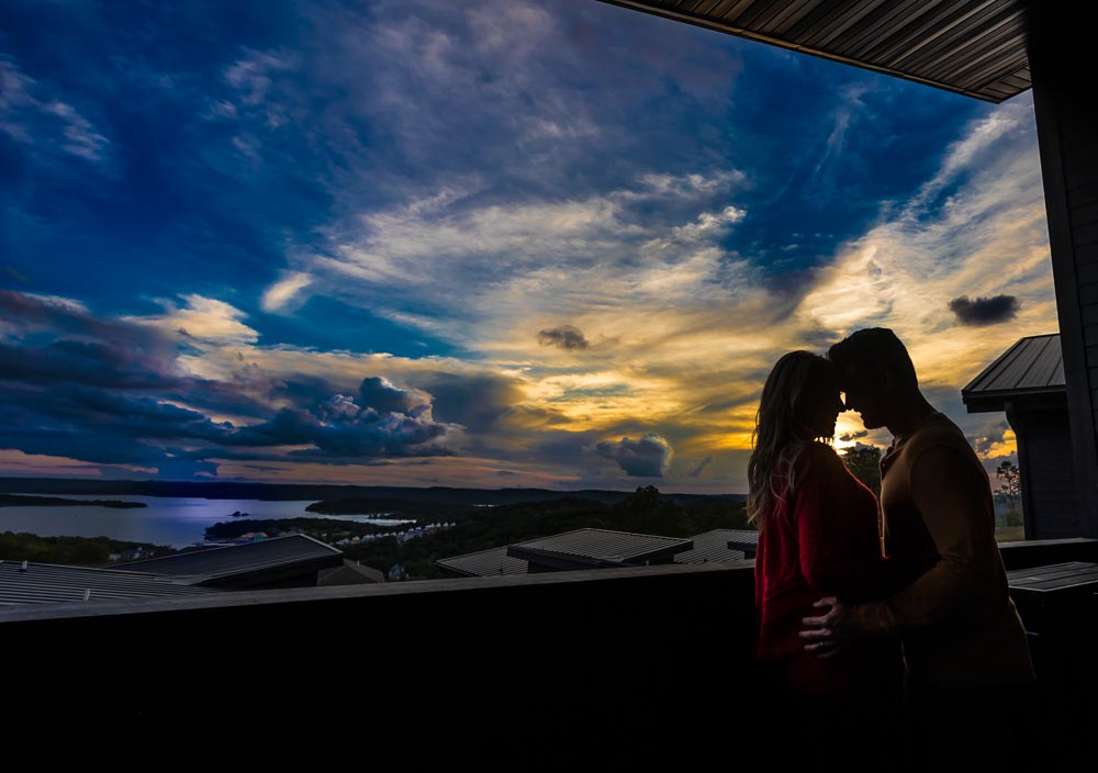 Couple silhouetted at sunset on a suite veranda above the lake