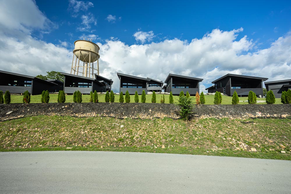 Row of Grotto suites behind a green lawn with the water tower