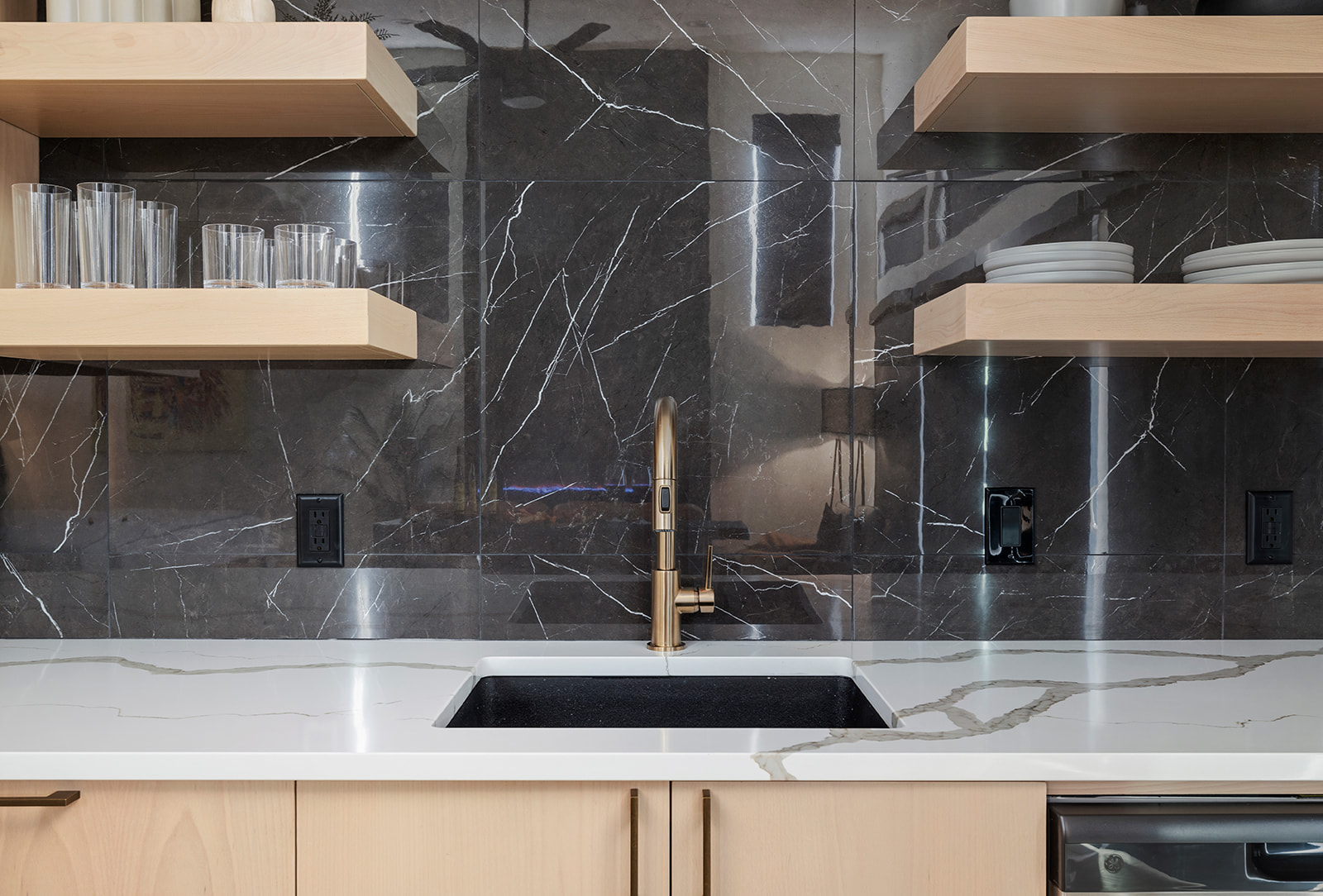 Kitchenette sink with brass faucet and marble backsplash