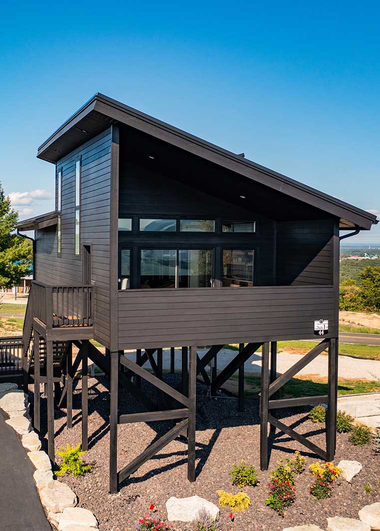An elevated Nest Suite with dark timber cladding and large windows