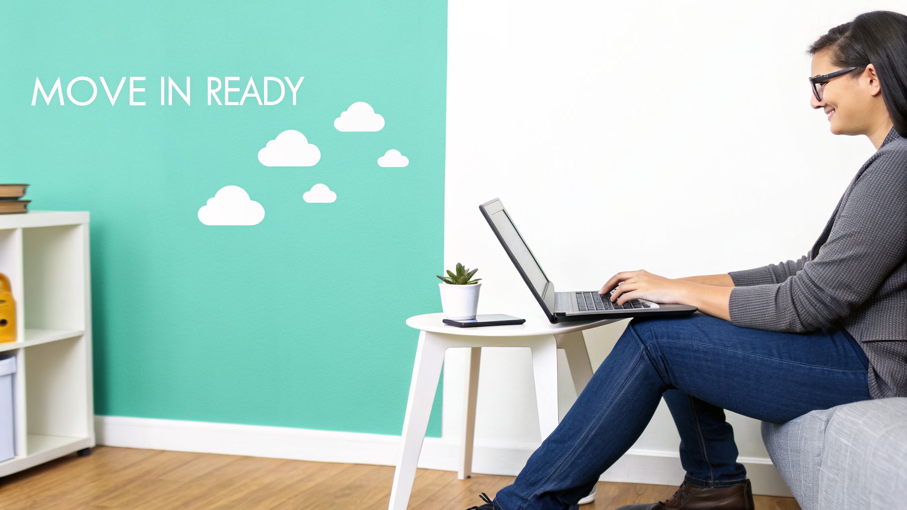 Smiling woman on a sofa working on laptop in a modern room with 'MOVE IN READY' wall.