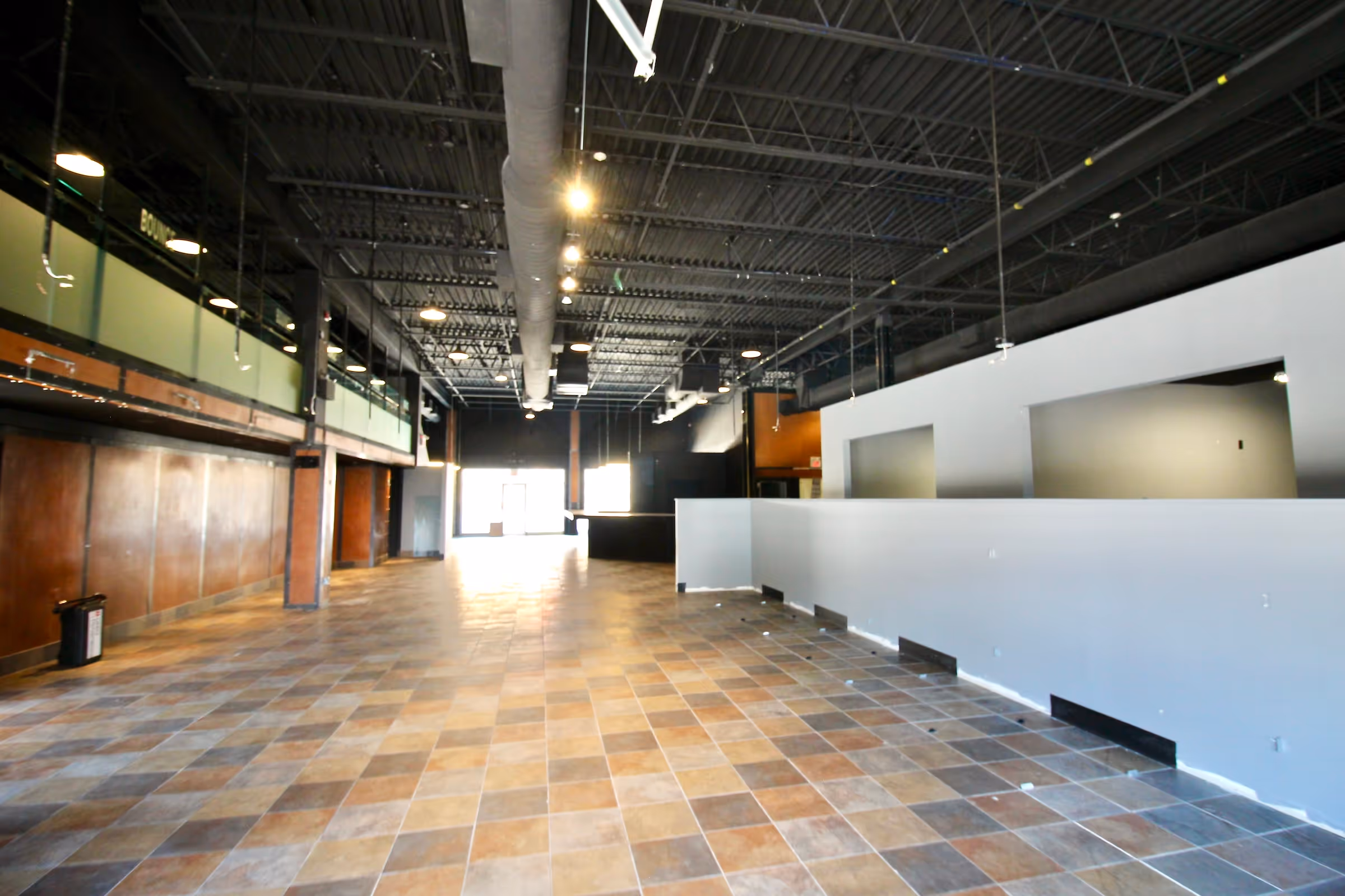 a second back view of the three story commercial building with parked vehicles in the adjacent parking lot.