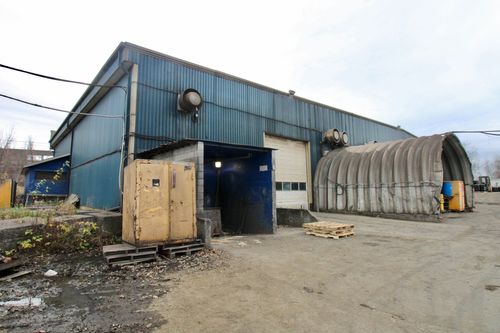 a second back view of the three story commercial building with parked vehicles in the adjacent parking lot.