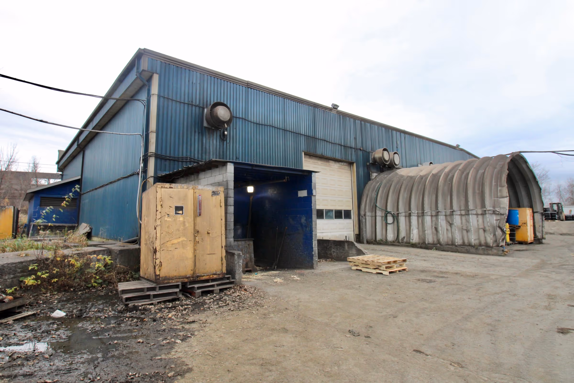 a second back view of the three story commercial building with parked vehicles in the adjacent parking lot.