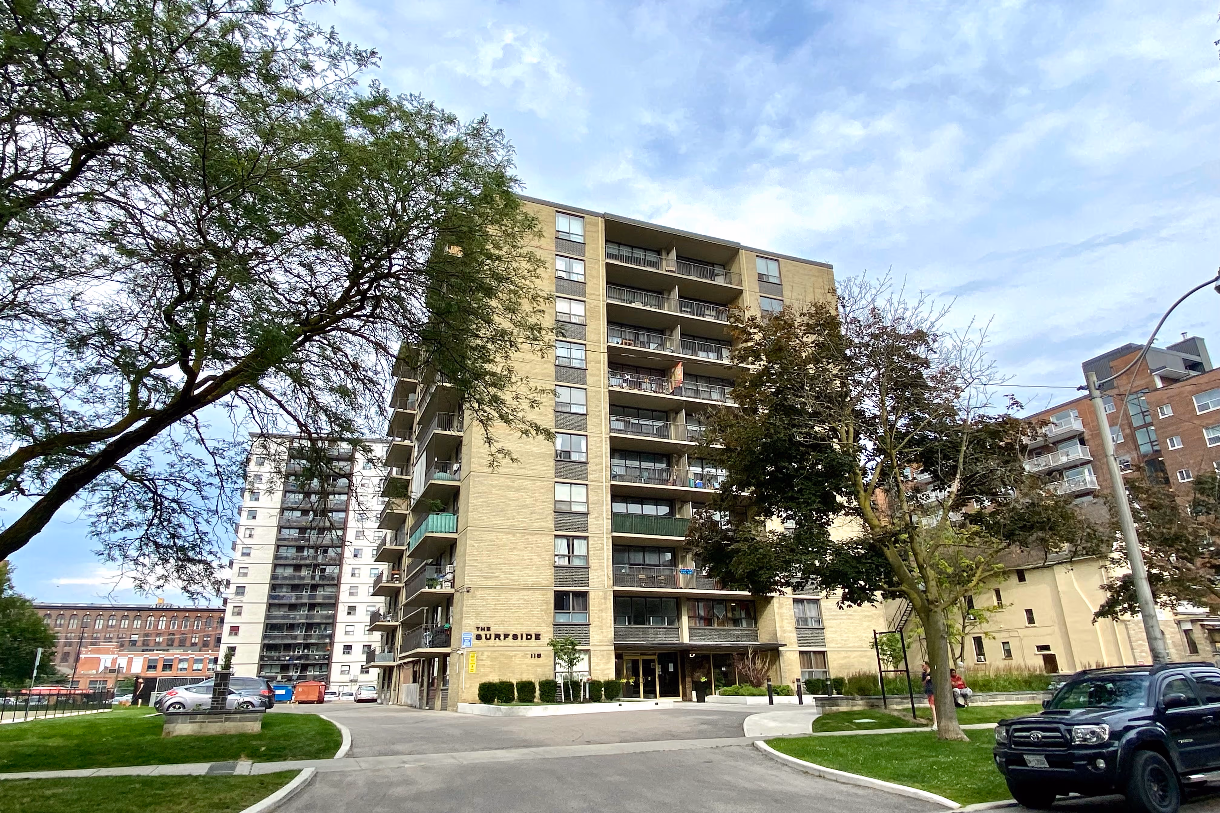 a second back view of the three story commercial building with parked vehicles in the adjacent parking lot.
