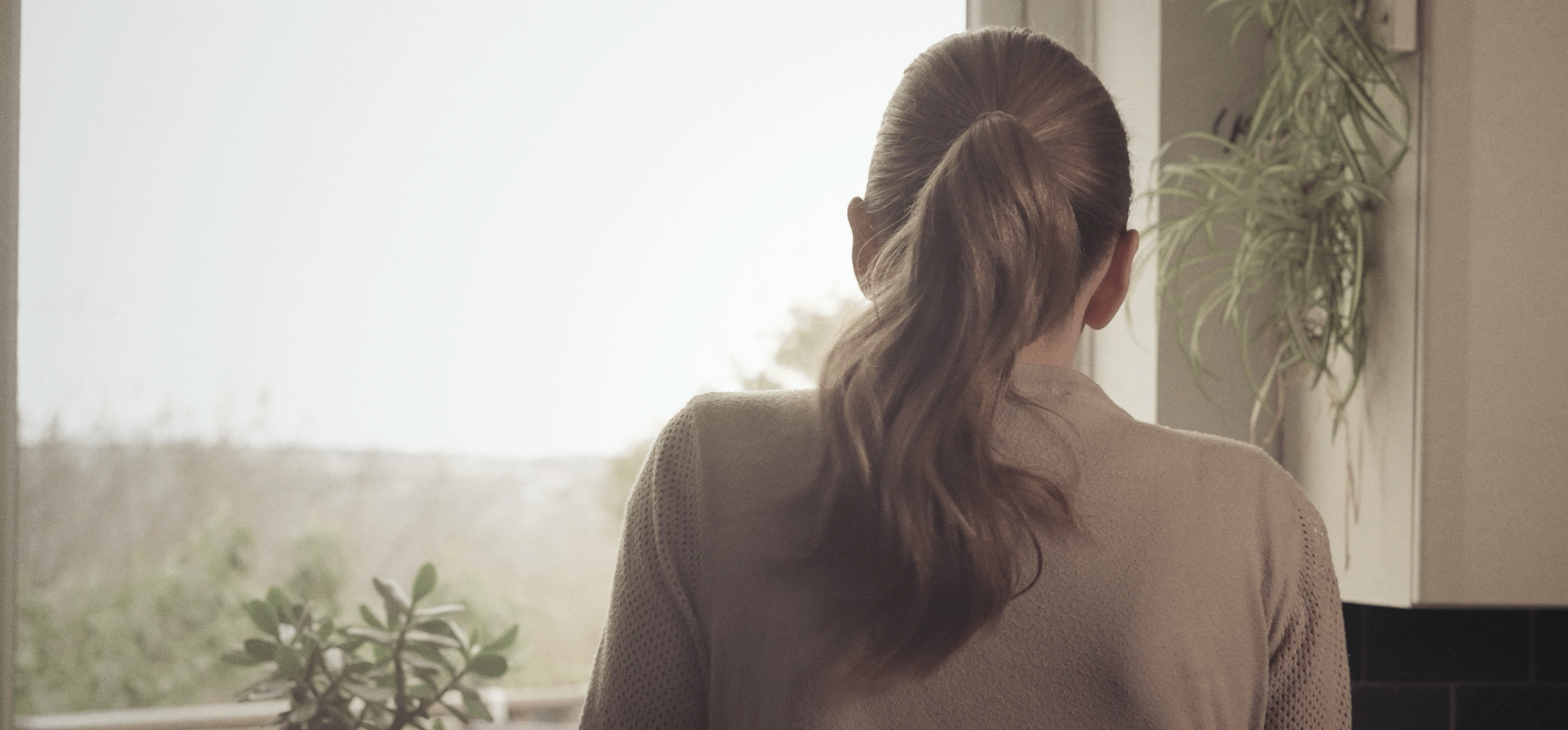 Campaign image of an affected other lady facing away from us.