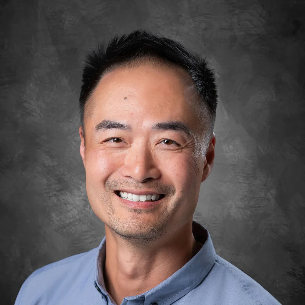 Headshot of Jason Chan, an Intentwise team member, wearing a blue collared shirt