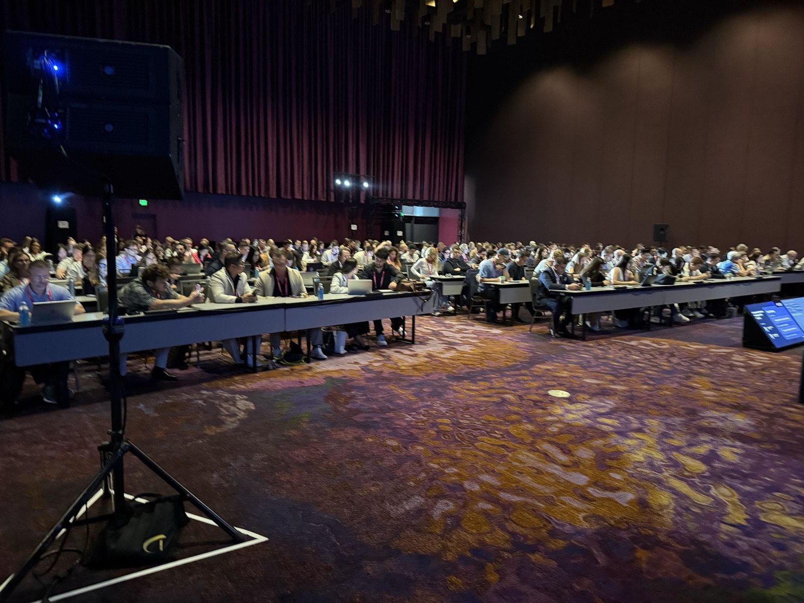 A packed workshop room at Amazon Accelerate, attendees at long tables with laptops