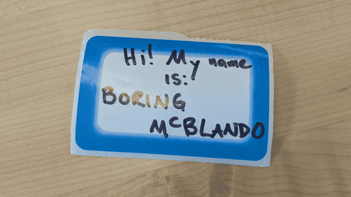 A name tag sticker on the counter with the word "Hi! My name is: Boring Mclando" written on it