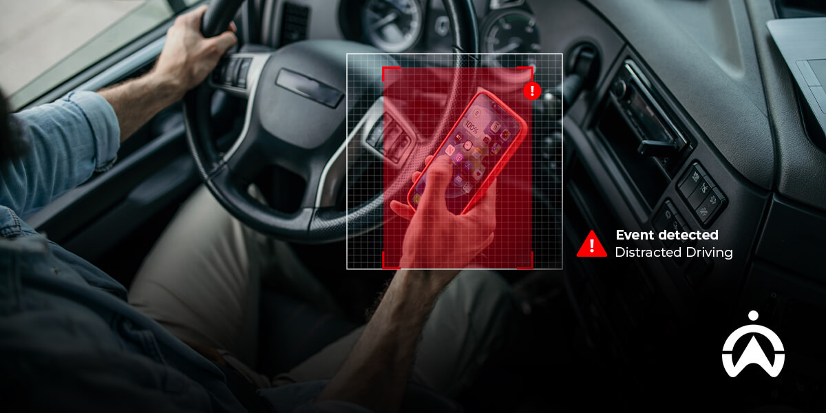 Cartrack truck camera system detecting distracted driver holding smartphone inside vehicle.
