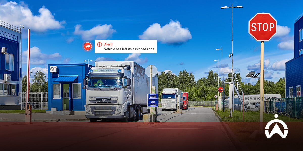 A white truck leaves a facility, with a warning alert on-screen indicating it has exited its designated zone near a stop sign.