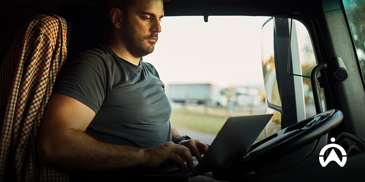 Cartrack fleet management dashboard with person reviewing vehicle and driver performance on tablet.